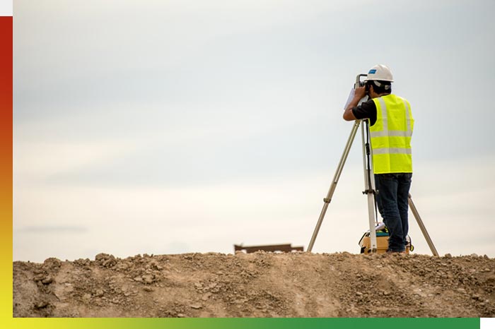 A person surveying ground on a site