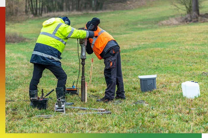 Workers taking a sample of soil